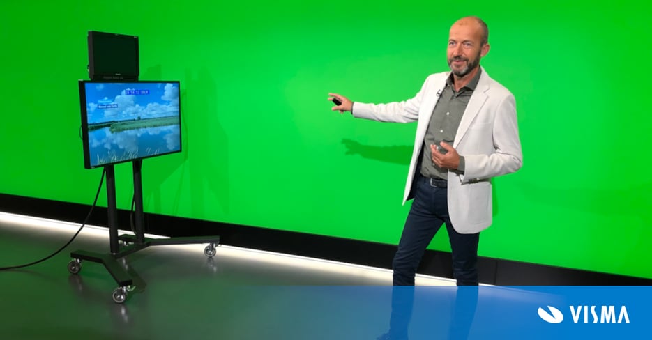Weatherman Reinier van den Berg in front of a green screen in a television studio